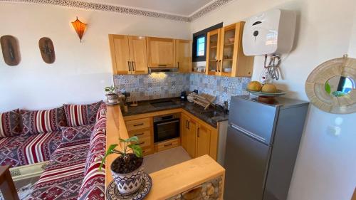 a small kitchen with a couch and a refrigerator at Apartment with 180 Seaview in Asilah