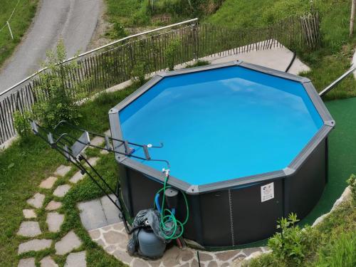 an overhead view of a large swimming pool with blue water at Landhaus Oberzinnegg in Saalbach Hinterglemm