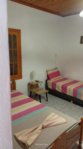 a room with two beds and a table with a desk at Yiannis House in Kalabaka