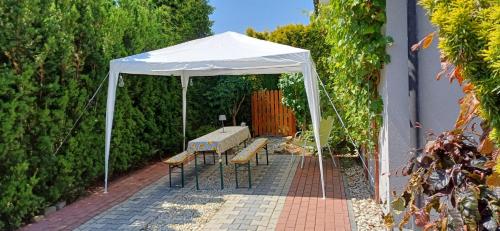 a white tent with a table and benches under it at Silent Home in Święta Katarzyna