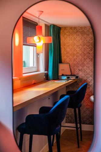 a room with two chairs and a desk with a laptop at MUZE Hotel Utrecht in Utrecht