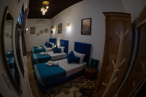 a bedroom with two beds and a mirror at Riad Soufiya Palace - Silent Luxury in Fès