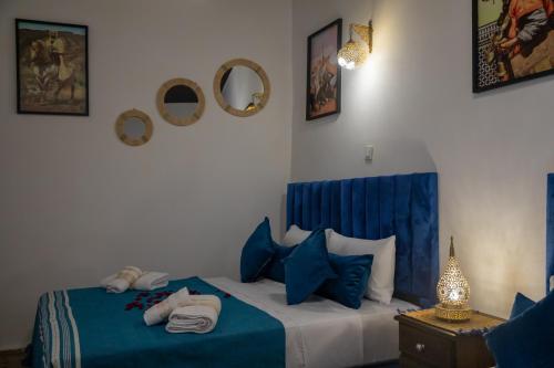 a bedroom with a bed with blue sheets and pillows at Riad Soufiya Palace - Silent Luxury in Fès