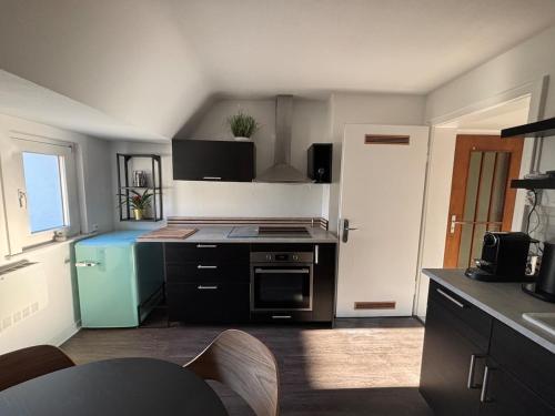 a small kitchen with a stove and a refrigerator at City Entdecker in Siegen