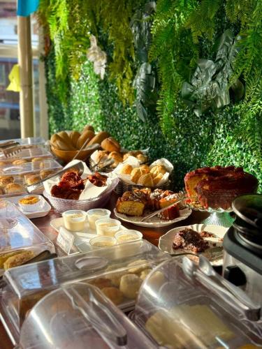 a table topped with lots of different types of food at Pousada La Acolhida in Cabo Frio