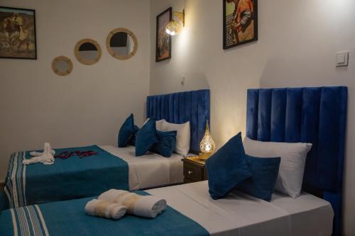 two beds in a room with blue and white at Riad Soufiya Palace - Silent Luxury in Fès