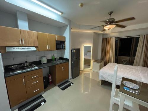 a room with a kitchen and a bed and a table at Studio condo near SM Clark, clark, & clark airport in Malabañas