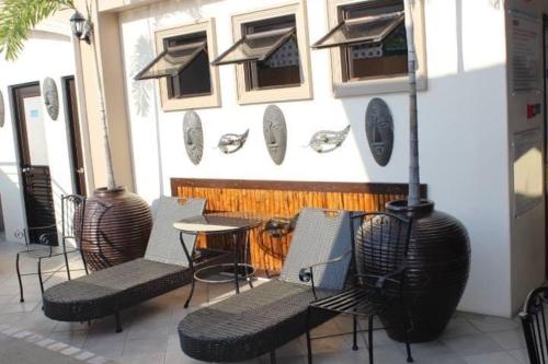 a group of chairs and a table in front of a building at Studio condo near SM Clark, clark, & clark airport in Malabañas