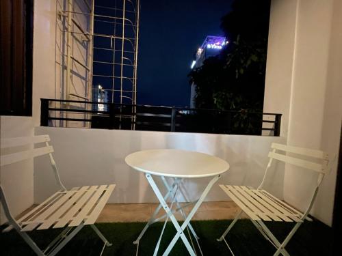 two chairs and a table on a balcony at night at Studio condo near SM Clark, clark, & clark airport in Malabañas