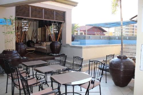 a patio with tables and chairs next to a pool at Studio condo near SM Clark, clark, & clark airport in Malabañas