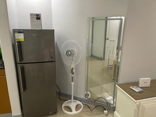 a kitchen with a refrigerator and a fan at Studio condo near SM Clark, clark, & clark airport in Malabañas