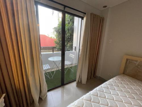 a bedroom with a large sliding glass door with a balcony at Studio condo near SM Clark, clark, & clark airport in Malabañas