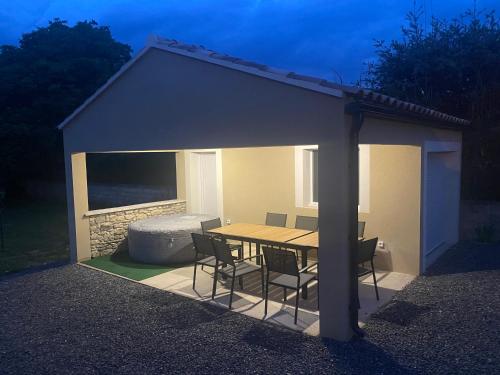 a pavilion with a table and chairs under it at Villa Les Rompudes in Quissac