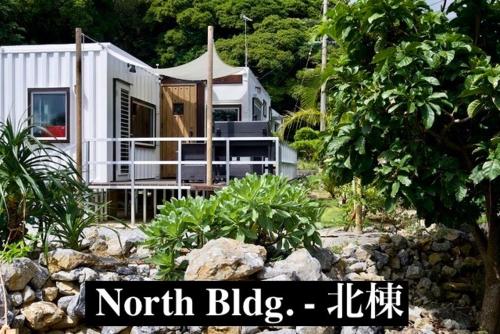 a small white house in the middle of a garden at Vacation Village Okinawa - Nakijin in Nakijin