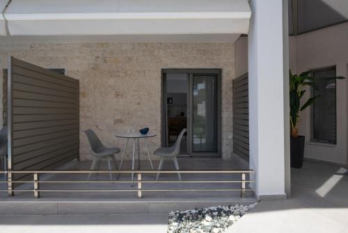 a patio with two chairs and a table on a house at Leon Villas in Nikiti