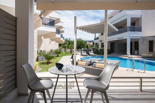 a patio with a table and chairs and a pool at Leon Villas in Nikiti