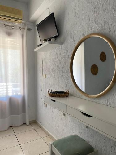 a bathroom with a mirror and a tv on a wall at Cozy Apartments in Istron