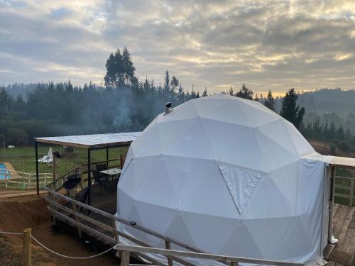 a large white tent sitting in a field at Domos el Quillay in Concepción