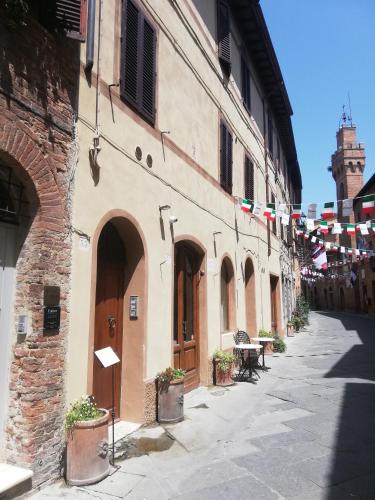 an alley with flags and a building with a street at Lovely Home - Spazio per le biciclette in casa in Buonconvento