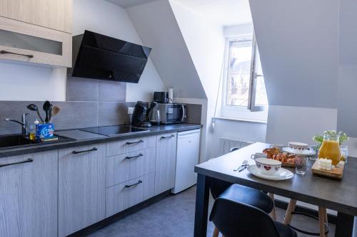 een kleine keuken met een tafel en een aanrechtblad bij Appartement cosy centre historique in Thann