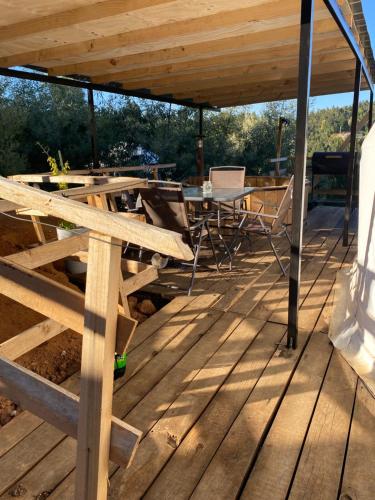 a wooden deck with a table and chairs on it at Domos el Quillay in Concepción