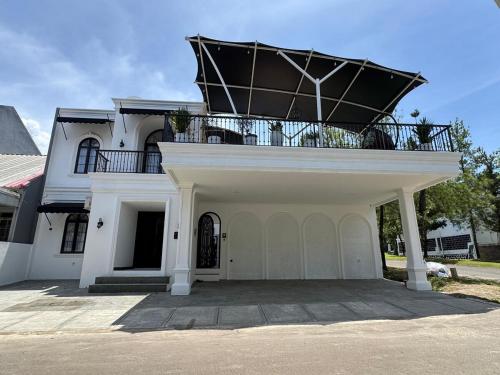 ein großes weißes Haus mit Balkon darüber in der Unterkunft Phoenix Villa at Sentul City in Bogor
