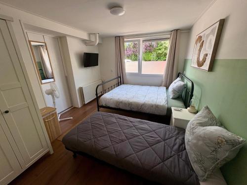 a small room with two beds and a window at The Sleep Studio in Sint Annaland