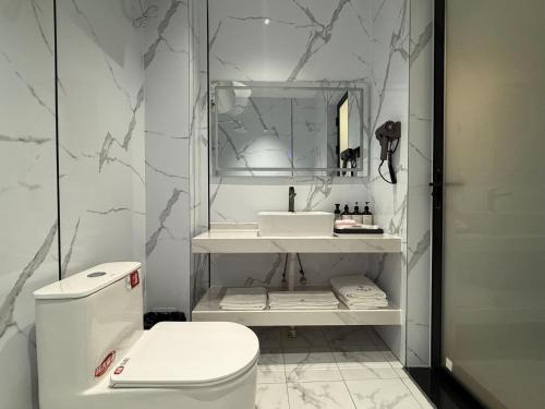 un bagno bianco con lavandino e WC di 合悦精品商务酒店 a Roga