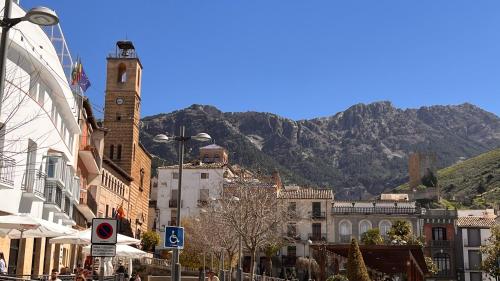 a city street with buildings and a mountain in the background at Casa caramujo in Quesada