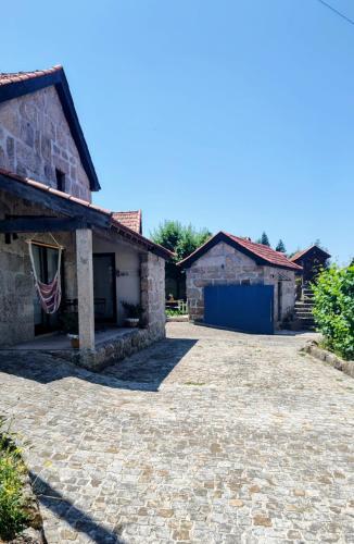 an empty driveway in front of a stone house at Casas do Arrabalde in Amarante