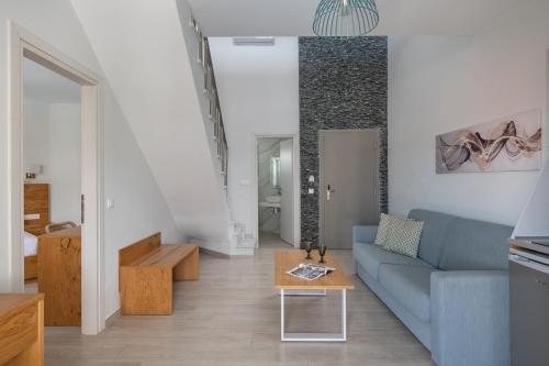 a living room with a blue couch and a table at Leon Villas in Nikiti