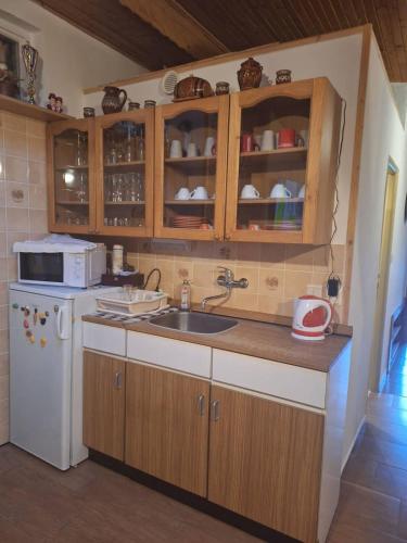 a kitchen with a sink and a microwave at Chata Mária in Bojná