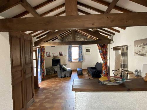 un séjour avec une cuisine et un salon avec poutres en bois dans l'établissement Maison des Cévennes, à Arphy