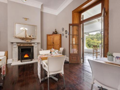 a dining room with a table and a fireplace at Caledon Grace Guesthouse in Caledon