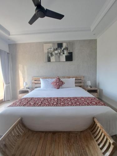 a bedroom with a large bed with a ceiling fan at Paddy Villa Sanur in Sanur