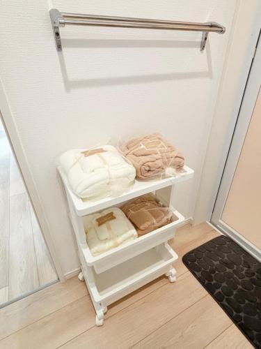 a towel rack with towels on it in a closet at ZZOKIAI紫葉 30-second walk to the seaside! You can see the sea from every floor! 4LDK maximun 10 people! in Itoman