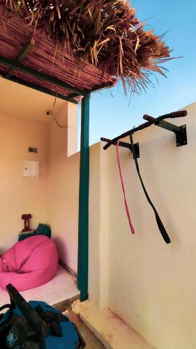 a room with a bed with a straw roof at Laila's Home in Siwa