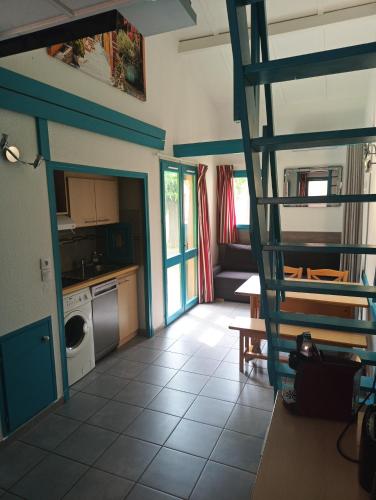 une cuisine avec un escalier en colimaçon dans une maison dans l'établissement Maisonnette Topaze bleu, à Argelès-sur-Mer