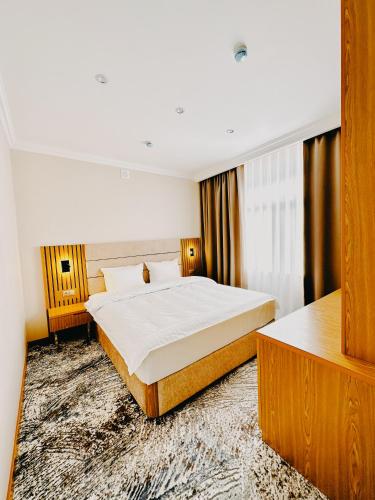 Ένα ή περισσότερα κρεβάτια σε δωμάτιο στο DAMIR HOTEL