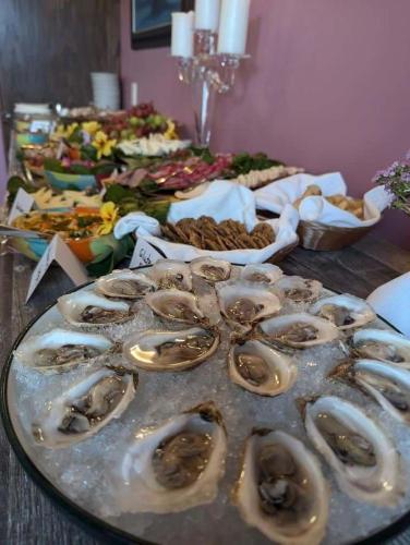 a table full of oysters on a table with other foods at Sugar Hill Inn in Norris Point