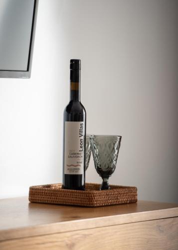 a bottle of wine and a glass on a table at Leon Villas in Nikiti
