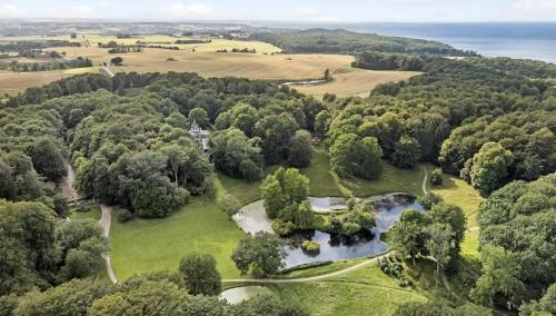 an aerial view of a park with trees and water at Liselund Ny Slot Hotel in Borre