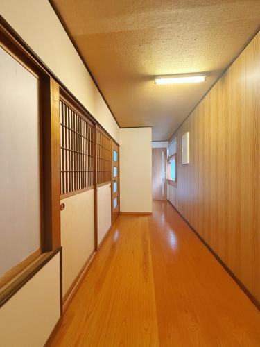 an empty hallway with wood floors and a door at 和美庵 有7个卧室和宽敞的餐厅客厅 整栋出租 可住18人 国分寺旁 距车站 朝市 古街等景区步行6分钟 in Takayama