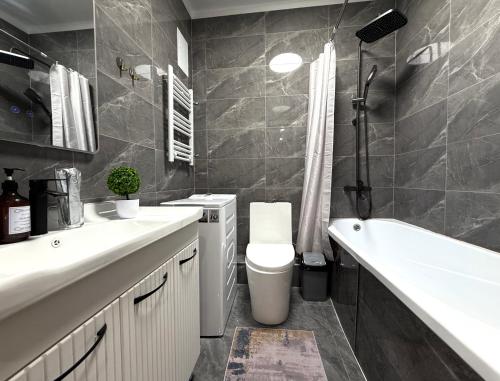 Un baño con lavabo, inodoro y bañera. en Замечательная Раимбек резиденс 20-63 & питьевая вода подарок, en Almaty