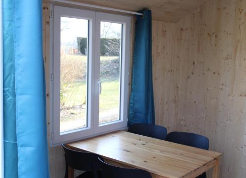 a table and chairs in a room with a window at Camping Le Balcon de Chartreuse in Miribel-les-Échelles