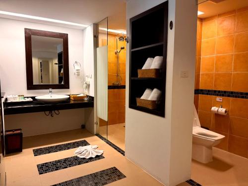 a bathroom with a sink and a toilet and a mirror at Anyavee Tubkaek Beach Resort in Tab Kaek Beach