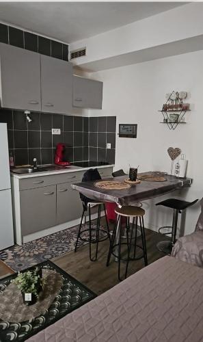 - une cuisine avec une table et quelques tabourets dans l'établissement Studio 23 m2, proche centre, calme, WIFI, pk, à Montpellier
