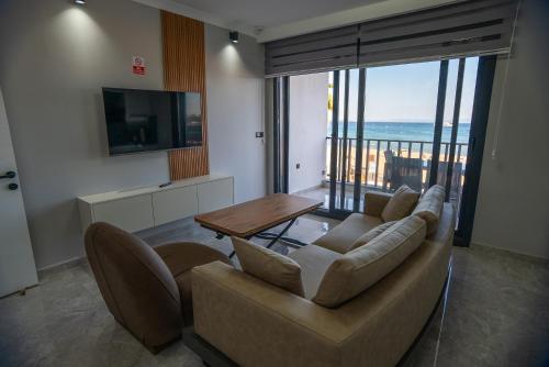a living room with a couch and a table at Sürer Apart Altınkum in Didim