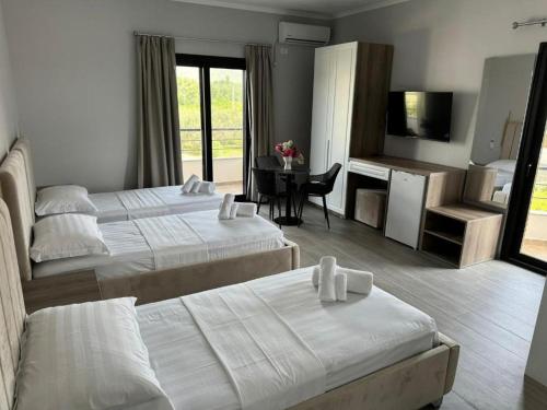 a hotel room with two beds and a table at Hotel 4Palmat in Orikum