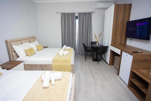 a hotel room with a bed and a television at Hotel 4Palmat in Orikum